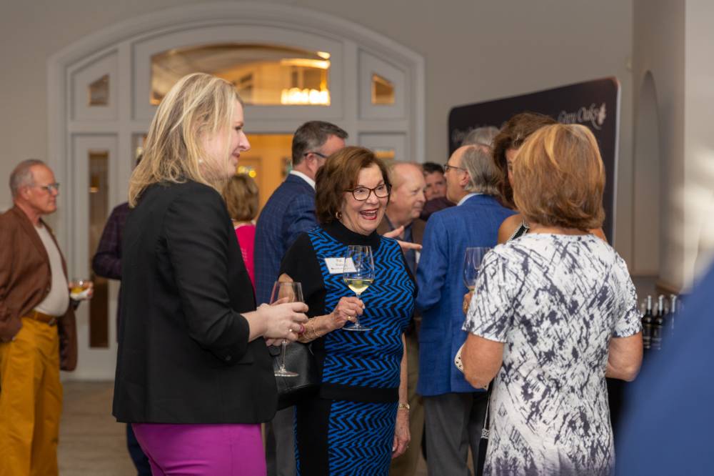 Pat Waring smiling and talking with other event guests